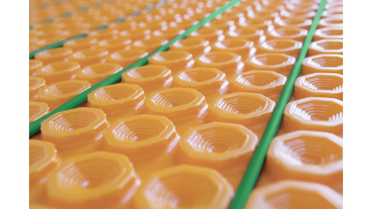 Orange Noppenplatte mit grünen Rohren.